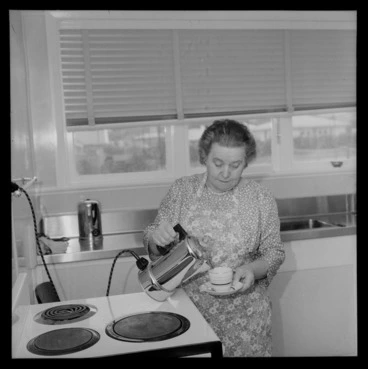 Image: Mrs Mabel Howard, in her new house in Karori, Wellington, showing her making a cup of tea
