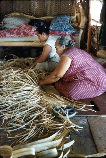 Image: Tepou Marsters and her adopted daughter weaving pandanus mats on the floor of the family sleeping house
