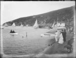 Christchurch Sailing and Power Boat Club, with sloop type sail boats racing and unidentified spectators lining the beach front, steep hillside with a few houses beyond, Redcliffs, Christchurch