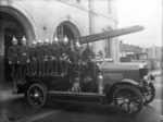 The Wanganui fire brigade, with a dog, seated on a fire engine outside the Central Fire Station