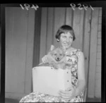 Unidentified woman with a dog in her bag at the Champ dog show, Wellington