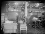 An interior view of the butter factory, showing a processing machine with some butter in it, a trolley with some butter in it and some butter on scales, Heretaunga Dairy Co-op Ltd, Heretaunga Plains, Hawkes Bay