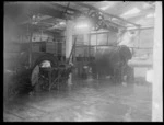 An interior view of the butter factory, showing processing machines with a load of butter on a tray and in one of the machines, Heretaunga Co-op Dairy Co Ltd, Heretaunga Plains, Hawkes Bay