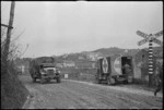 Vehicles of 2 NZ Divison near a railway crossing on road near Italian Front lines, World War II - Photograph taken by George Kaye