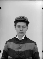 Portrait with a backdrop of an unidentified woman wearing a striped jockey's outfit and cap