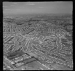 Mt Roskill residential housing subdivisions with the Wesley Intermediate School and Stoddard Road, and the Manukau Harbour beyond, Auckland City