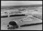 Egmont Box Company factory with saw mill and stacked lumber, with the township of Tokoroa beyond, Waikato Region