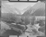 Mount Cook and Southern Lakes Tourist Coach on the Hermitage Road, Mount Cook Village, with Mount Cook beyond, Mount Cook National Park, Canterbury Region