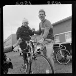 Unidentified cyclist with young boy balanced on his bike, Petone, Lower Hutt