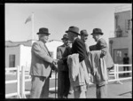 Sir Charles Norwood with Mr Nuffield after the arrival of TEA [flying boat?] at Mechanics Bay, with Mr Gordon second on right with other unidentified men, Auckland City Harbour