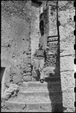 D E Jordan coming down one of the narrow corkscrew streets in the village of Aquafondata, Italy, World War II - Photograph taken by George Bull