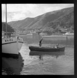 Group of unidentified boys in a dinghy, next to a fishing boat which reads 'WN 126', Picton, Marlborough Sounds