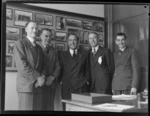 Group portrait at Whites Aviation Office, (L to R) E A Robinson (Whites), G Wells (Tasman Airways), J Mollison, J Harley (Castrol), Leo White (Whites), Auckland City