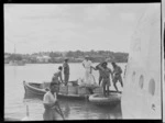 Group of unidentified men in boats alongside Tasman Empire Airways Ltd Short Empire flying boat 'Aotearoa', Suva, Fiji
