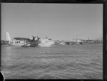 View of the TEAL flying boat 'Aotearoa' ZK-AMA in Mechanics Bay with sister flying boats 'Awarua' ZK-AMC and 'New Zealand' KZ-AME beyond, Auckland Harbour