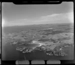 View to Matapouri Bay with sandy beach and settlement to hilly farmland beyond, looking south to Ngunguru Bay, Northland Region