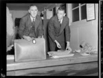 Mr Noel Lendrum (left) and Mr N Falla, of PAWA (Pan American World Airways), sorting out mail after arrival of PAWA clipper from America