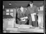 Mr Noel Lendrum (left) and Mr N Falla, of PAWA (Pan America World Airways), sorting mail after arrival of PAWA clipper from America