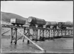 "A" 196 steam locomotive hauling kauri logs across Maori Creek, near Piha