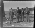 Timaru personalities, next to an Auster airplane, showing (L to R), D Greig, Mac ?, Harry L Wigley and an unidentified man, Timaru