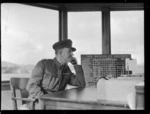 Flight Lieutenant 'Chips' Carpenter, Air Traffic Officer talking on the phone, in control tower at Harewood Aerodrome (Christchurch International Airport)