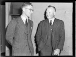 Portrait at a Royal NZ Aero Club Annual Meeting of (L to R) Mr R G Bannister (new RNZAC Secretary) and Mr A G Macfarlane the Retiring RNZAC Secretary in front of an unknown building, [Auckland City?]