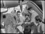 Captain R Ellison (right) examines piupiu skirt of Guide Rangi wearing Kahu rurururu cloak at Bristol Freighter Tour stop, Rotorua, Bay of Plenty