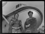 Guides for the Bristol Freighter Tour, Emily and Bubbles, dressed in traditional Maori costume, in front of Bristol Freighter 'Merchant Venturer' aircraft, Rotorua, Bay of Plenty
