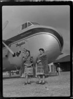 Guides for the Bristol Freighter Tour, Emily and Bubbles, dressed in traditional Maori costume, in front of Bristol Freighter 'Merchant Venturer' aircraft, Rotorua, Bay of Plenty