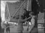 Captain Ellison helping schoolgirl as she jumps from Bristol Freighter transport aeroplane 'Merchant Venturer', [at Hood Aerodrome?], Masterton