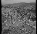 View south over Wellington City with Parliament Buildings, Wellington Railway Station and Featherston Street in foreground to Victoria University and Brooklyn Hill beyond