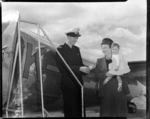 Commander Tom Mounsey and Mrs L P Harker with baby, boarding aircraft Kuaka, Rotorua