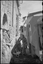 A C McCartney and A J Thompson outside the 22 NZ Battalion Regimental Aid Post in Rimini, Italy, World War II - Photograph taken by George Kaye