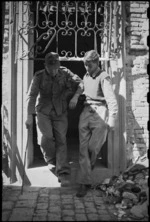 J K Quinn assists wounded World War II German prisoner from the 22 NZ Battalion RAP in Rimini, Italy - Photograph taken by George Kaye