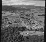 View over the town of Ohakune with lawn bowls greens in foreground to Goldfinch Street with the Farmers Co-Op building, to Mount Ruapehu in cloud beyond, Manawatu-Whanganui Region