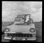 Posters advertising South Pacific Airlines of New Zealand on a Holden bonnet, Whakatane Airport opening