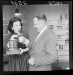 Sheila Bradley, being presented with canned food, including Toheroa clams, by an unidentified man