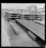 Exterior view of Auckland City Council parking building and bus terminal with W R Twigg Ltd and R & E Tingey & Co Ltd buildings behind