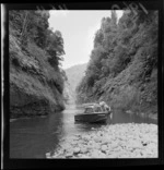 Cecil Davies, on his jet boat 'Rangimarie' on the Whanganui River, including unidentified man and boys