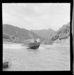 Cecil Davis, on his jet boat 'Rangimarie' on the Whanganui River, including an unidentified man
