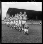 Taita Rugby League Football Club team mascot, a young boy, leading players onto field