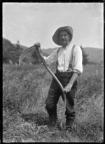 Albert Percy Godber holding a scythe, clearing a section at Pinehaven.