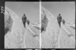 Edgar Williams' Mount Aspiring trip, view of two mountaineers with ropes and ice axes traversing a snow slope on Mount Aspiring, Central Otago Region