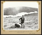 Wally Neill and dog approaching top of Field Peak, Tararua Ranges