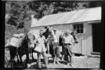 Edgar Williams and two unidentified men, with pack horses, outside Howden Hut, Southland Region