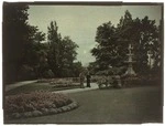 Oamaru Public Gardens, Otago Region, showing flowerbeds and two unidentified men standing on path near Craig Fountain