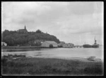 Stewart Island. View of the wharf at Oban, with Presbyterian Church on hill above, the SS Theresa Ward berthed at the wharf, and part of Half Moon Bay.