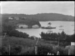 Stewart Island. View of the wharf at Oban, with Presbyterian Church on hill above, the SS Theresa Ward berthed at the wharf, and part of Half Moon Bay.