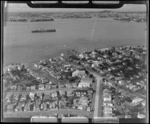 Devonport with residential housing, looking to Hobson Bay with an Aircraft Carrier entering the Waitemata Harbour, Auckland City