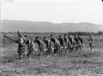 Row of men in semi-traditional Maori clothing, at Kaiwhaiki - Photograph taken by William Henry Thomas Partington